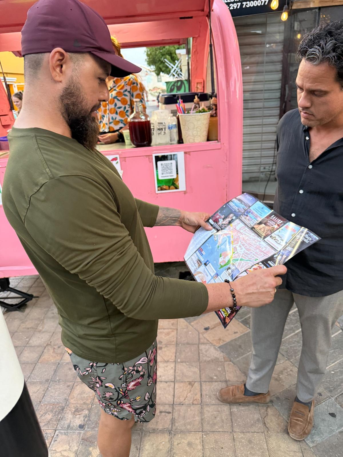 Benefits of Advertising Your Business with Aruba Discovery Visitors reviewing an Aruba Discovery guide while learning about local businesses and attractions in Aruba